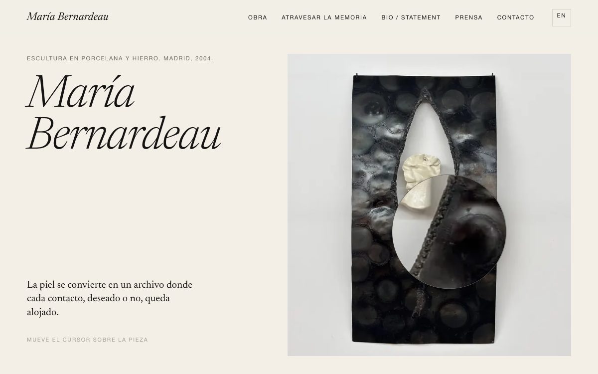 Inicio de mariabernardeau.com: fondo color papel, su nombre en cursiva grande, la frase «La piel se convierte en un archivo donde cada contacto, deseado o no, queda alojado.» y, a la derecha, una pieza de hierro negro con una porcelana blanca y una lupa redonda que la amplía.