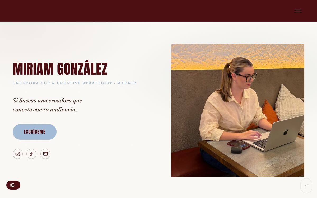 Inicio de miriamgonzalez.es: franja granate arriba, su nombre en tipografía Anton y una foto de Miriam trabajando con el portátil.