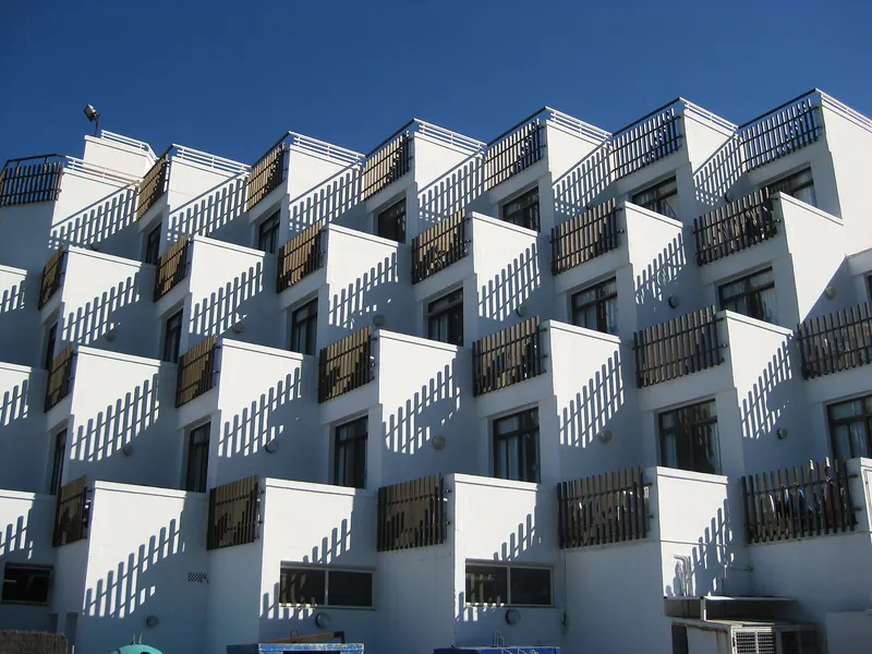 Edificio de viviendas blanco con terrazas en voladizo contra el cielo