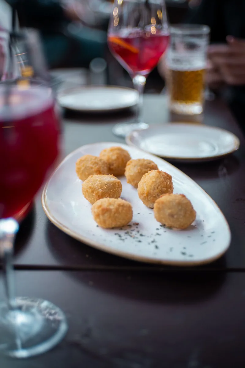 Croquetas de cocido recién fritas en un plato blanco