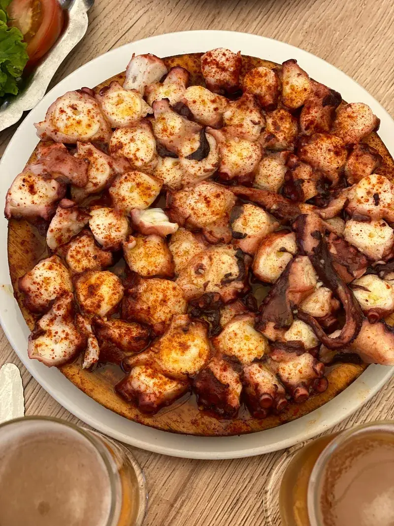 Pulpo con pimentón servido en plato de madera